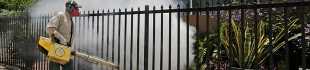 Mosquito control technician fogging a yard perimeter for mosquito reduction in Wilmington, NC